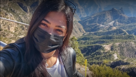 a woman standing in front of a mountain